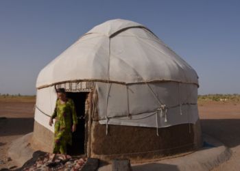 Femme ouzbèke sortant d'une yourte traditionnelle en Ouzbékistan.
