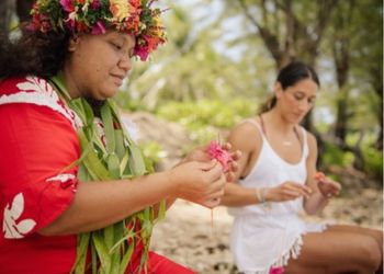 Femmes polynésiennes pratiquant des traditions culturelles sur une plage tropicale