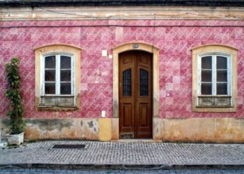 Maisons traditionnelles portugaises avec des façades colorées et des toits en tuiles rouges.