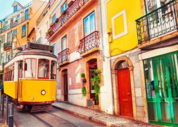Métro jaune traditionnel traversant les rues pittoresques de la ville au Portugal.