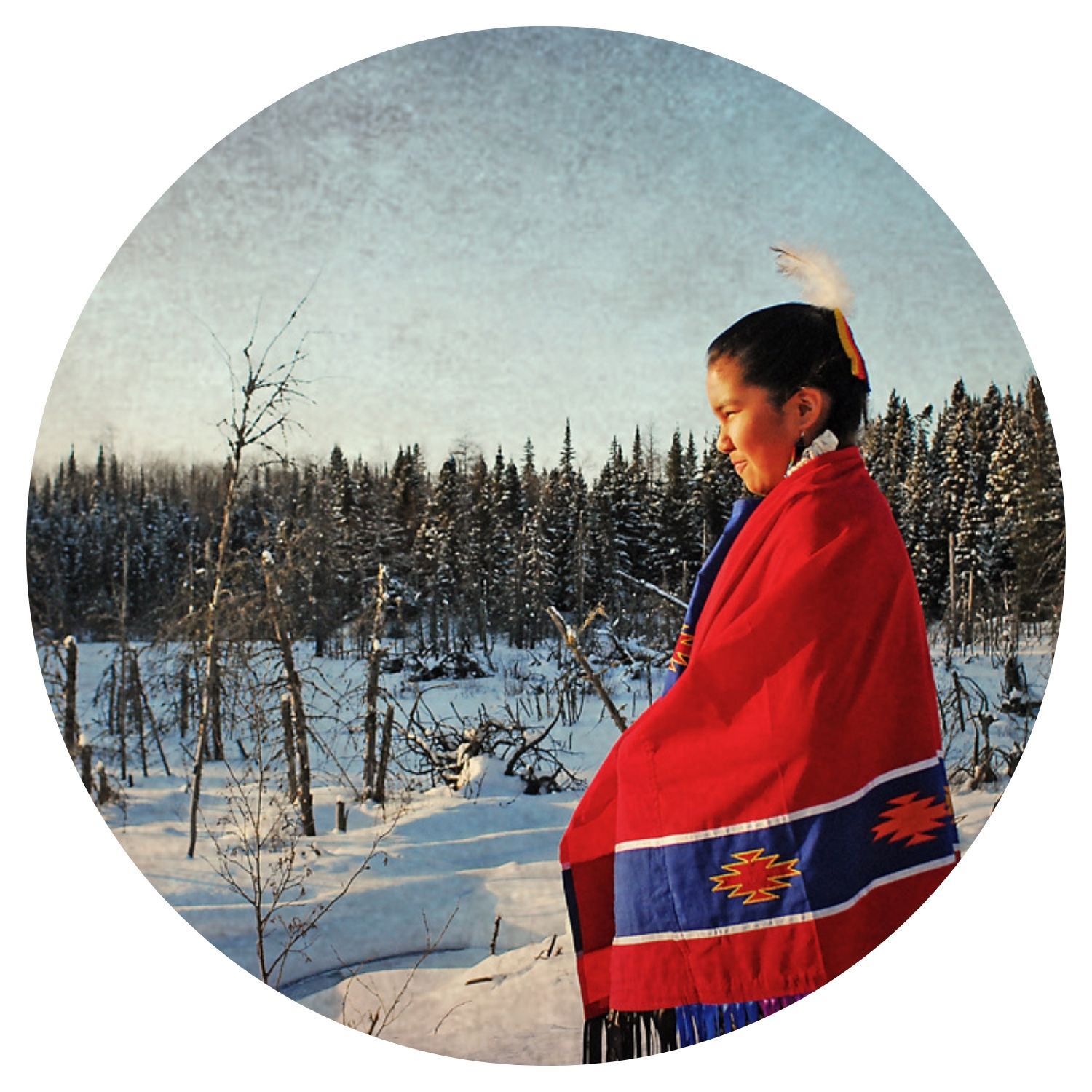 Jeune fille habillée en rouge, debout au milieu d'une forêt de sapins enneigée, représentant l'immersion totale dans la nature canadienne.